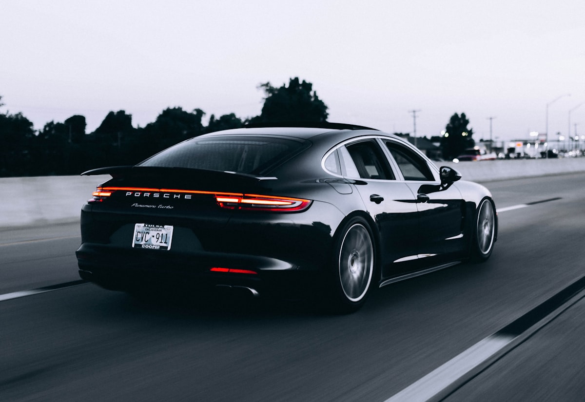 Xe sedan hiệu năng màu xanh điện chụp từ phía trước trong showroom Aureon Auto