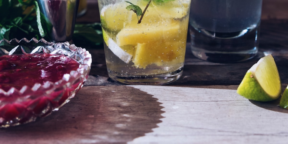 Kệ đồng sau quầy được chiếu sáng, xếp đầy chai rượu màu hổ phách