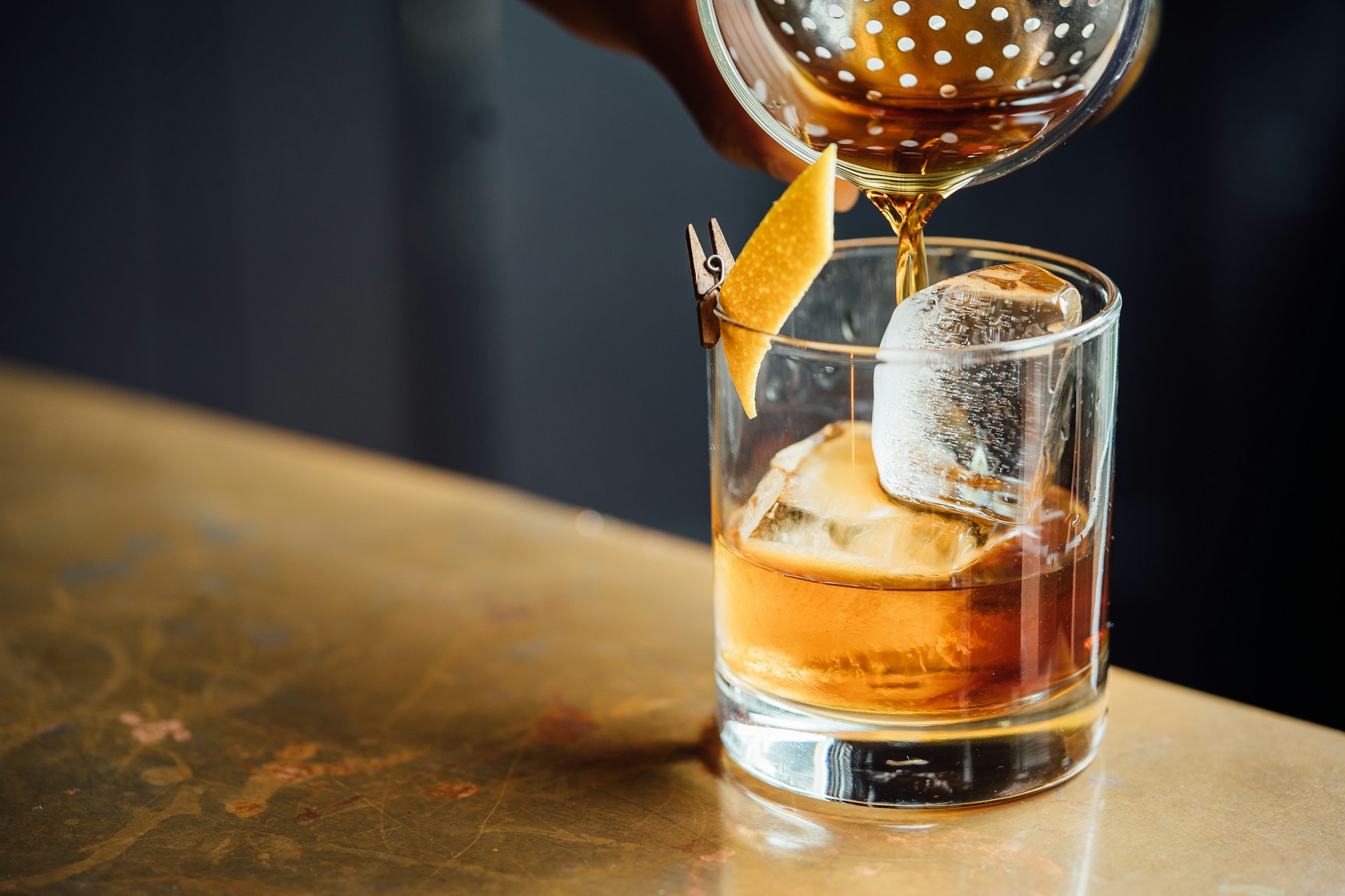Quầy cocktail ánh sáng dịu với bartender pha chế dưới sắc đồng ấm